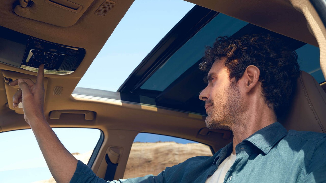 A man opening the Lexus NX's sunroof 